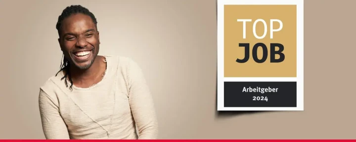 Banner mit einem Mitarbeiter und dem TOP JOB-Siegel.