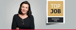 Banner mit einer Mitarbeiterin und dem TOP JOB-Siegel.