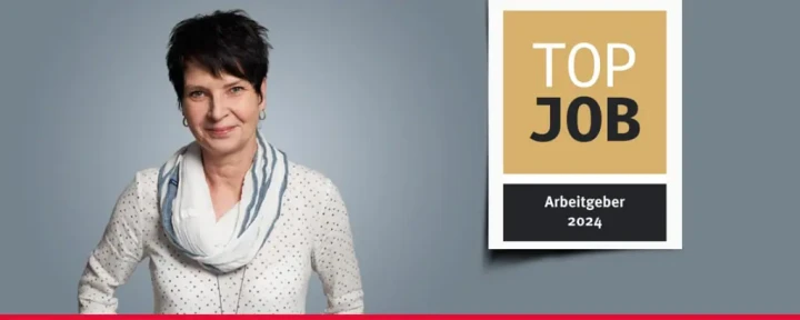 Banner mit einer Mitarbeiterin und dem TOP JOB-Siegel.
